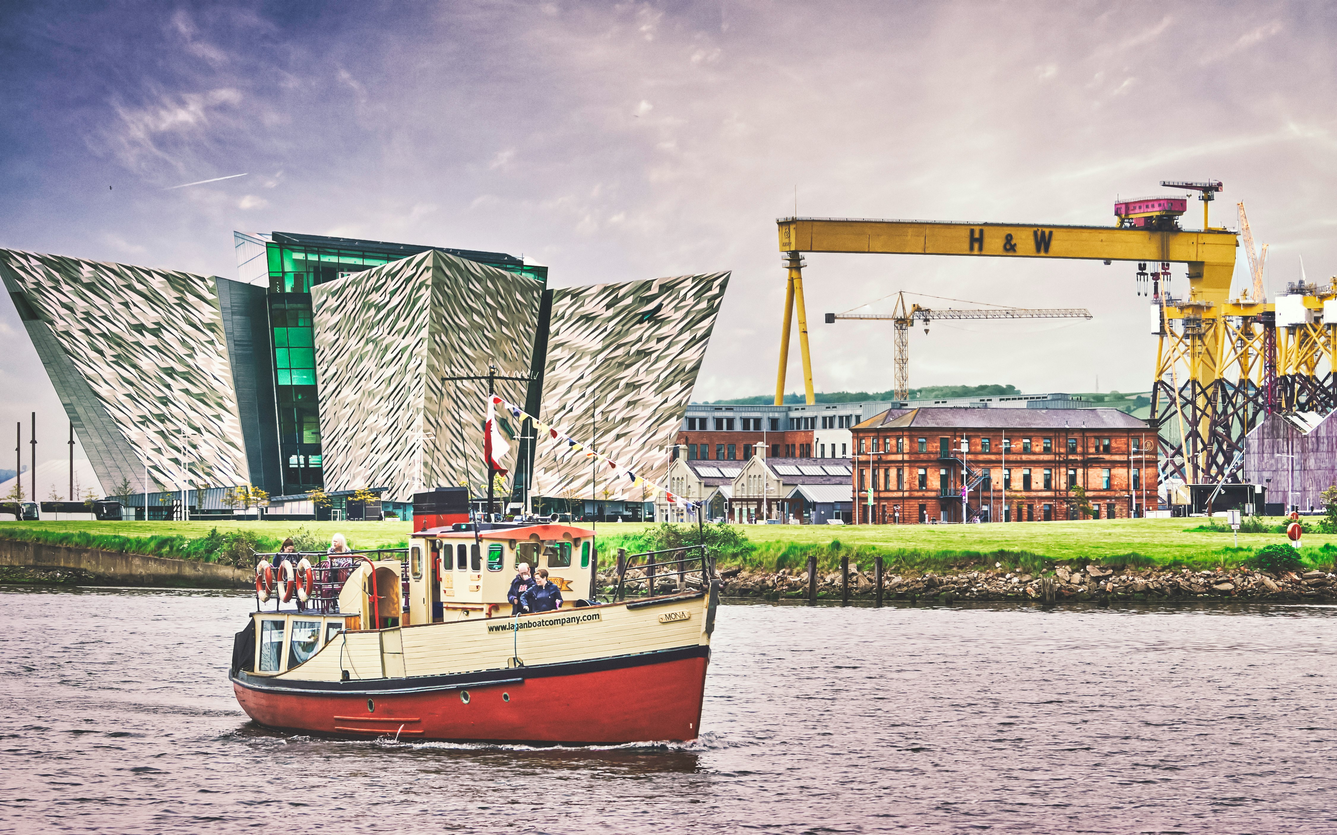 red and white boat on water near green and white building during daytime